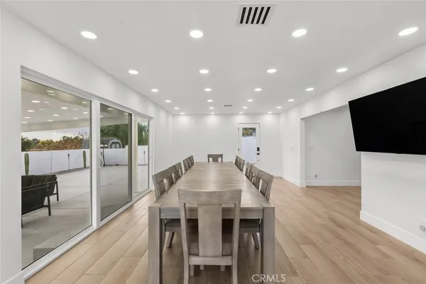 a view of a dining room with furniture wooden floor and a floor to ceiling window