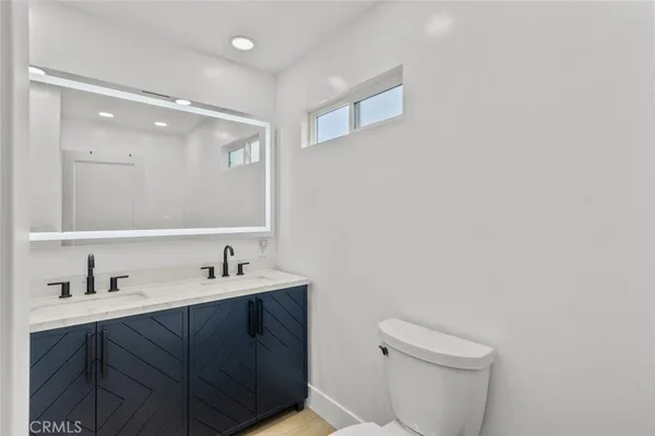 a bathroom with a sink a toilet and a mirror