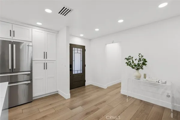 a view of kitchen with stainless steel appliances a refrigerator and wooden floor