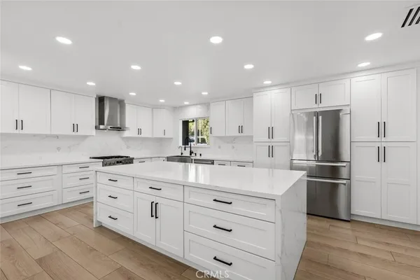 a kitchen with stainless steel appliances kitchen island and white cabinets