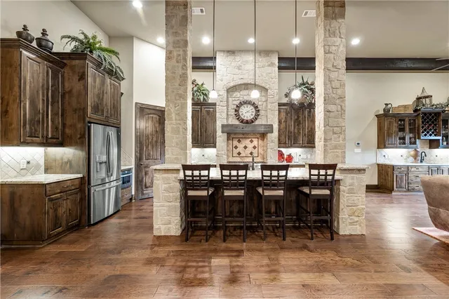 a kitchen with stainless steel appliances granite countertop a sink a stove and a wooden cabinets