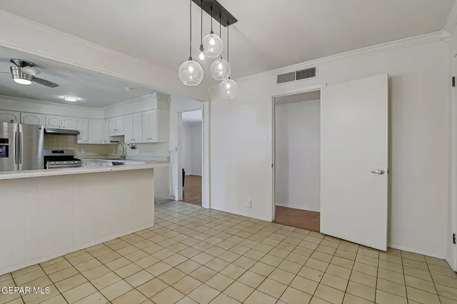 a kitchen with stainless steel appliances granite countertop a refrigerator and a stove top oven