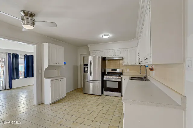 a kitchen with stainless steel appliances a refrigerator and a stove top oven