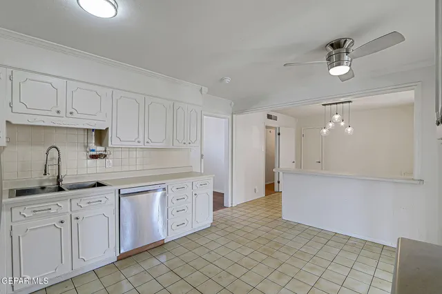a kitchen with white cabinets and sink