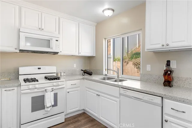 a kitchen with white cabinets and white appliances