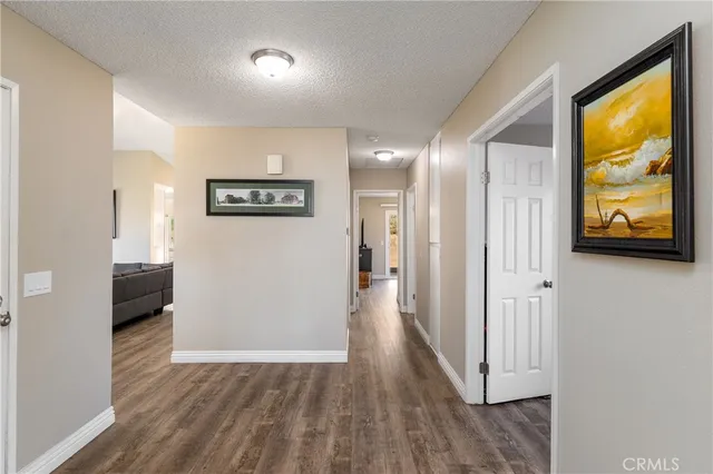 a view of a hallway with wooden floor and a living room