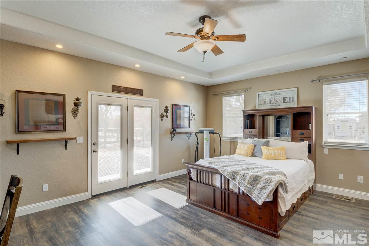 4925 Rancheria Road Fallon, NV 89406 - Photo 19 of 39 a bedroom with a large bed a flat tv screen and dresser