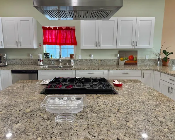 a kitchen with stainless steel appliances granite countertop a sink stove and cabinets