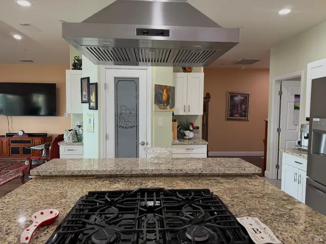 a kitchen with stainless steel appliances granite countertop a stove a sink and a refrigerator