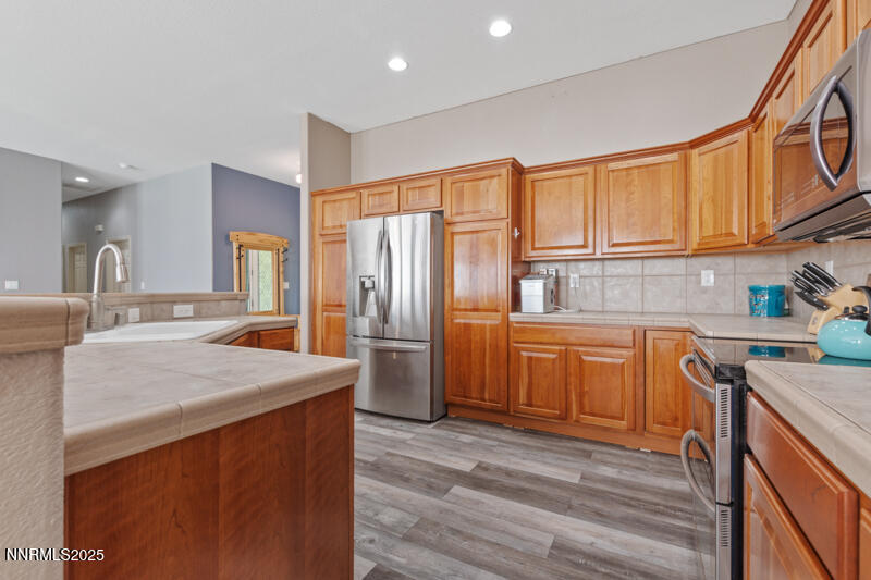 210 Nugget Avenue Dayton, NV 89403 - Photo 12 of 24 a kitchen with stainless steel appliances granite countertop a sink stove and refrigerator