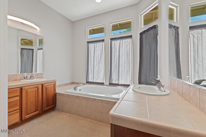 210 Nugget Avenue Dayton, NV 89403 - Photo 16 of 24 a bathroom with a tub a sink and a large mirror
