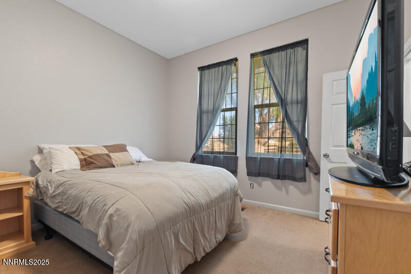 210 Nugget Avenue Dayton, NV 89403 - Photo 18 of 24 a bedroom with a bed and a flat tv screen on a dresser