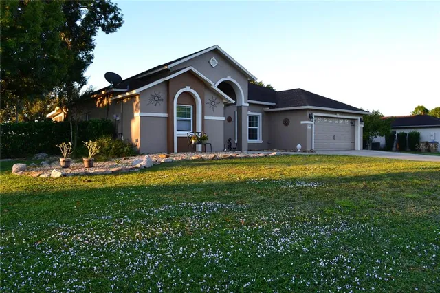 a front view of a house with yard and green space