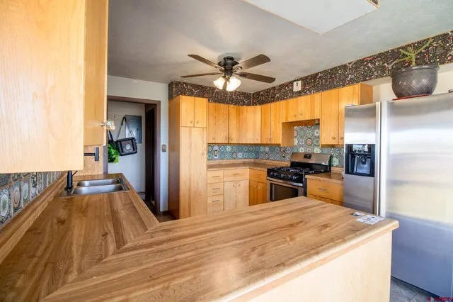 a kitchen with stainless steel appliances granite countertop a refrigerator and a stove top oven
