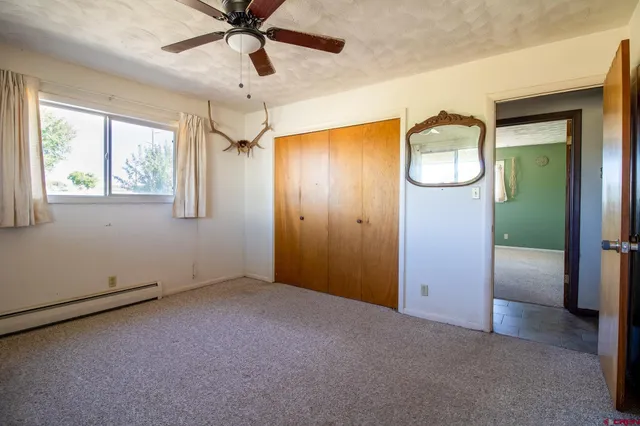 an empty room with fan and windows