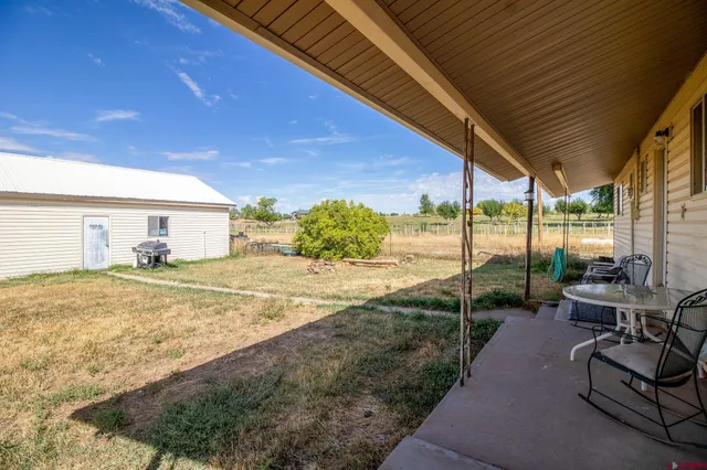 a view of a patio with table and chairs under an umbrella