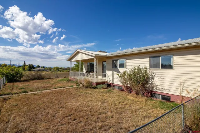a view of house with backyard and sitting area