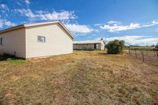 a backyard of a house with table and chairs