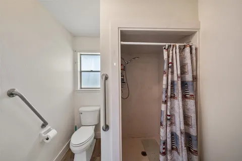 a bathroom with a toilet and a shower