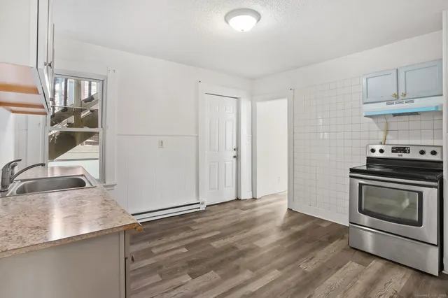 a kitchen with granite countertop a stove and a sink