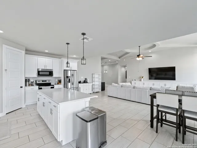 a large kitchen with kitchen island a sink stainless steel appliances and cabinets