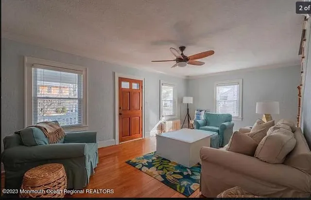 a living room with furniture ceiling fan and a window