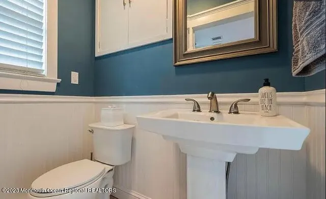 a bathroom with a sink a toilet and mirror