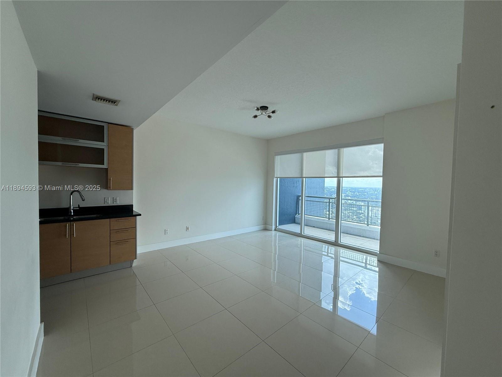 60 Southwest 13th Street, Unit 3809 Miami, FL 33130 - Photo 4 of 6 a view of an empty room with kitchen and window