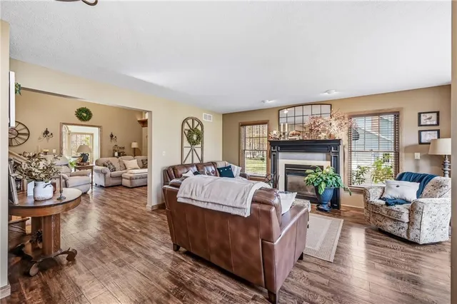 a living room with furniture fireplace and a large window
