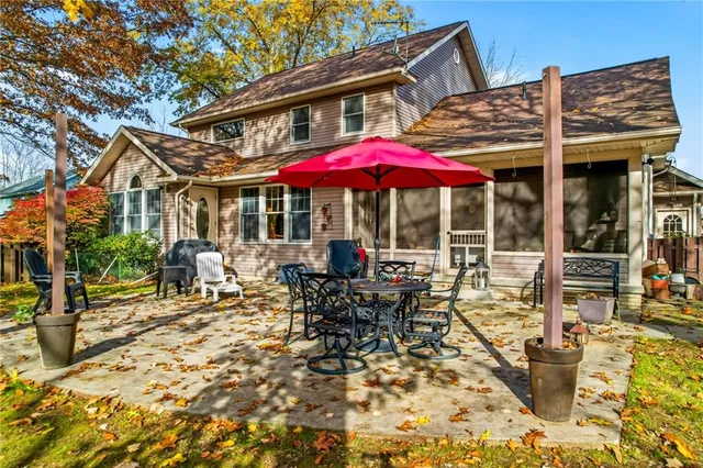 a patio with a table and chairs under an umbrella