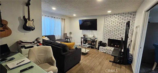 a living room with furniture a flat screen tv and a fireplace