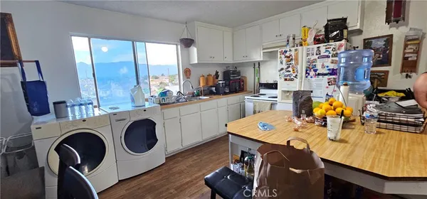a open dining room with stainless steel appliances furniture a rug and a kitchen view