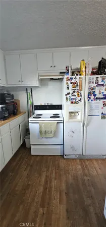 a kitchen with stainless steel appliances granite countertop a refrigerator a stove and a sink