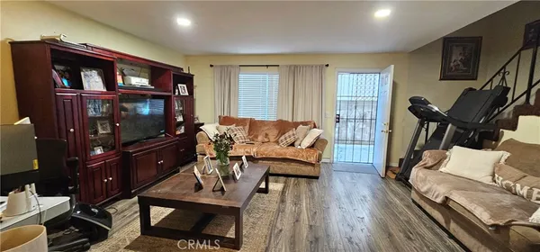 a living room with furniture a flat screen tv and a rug