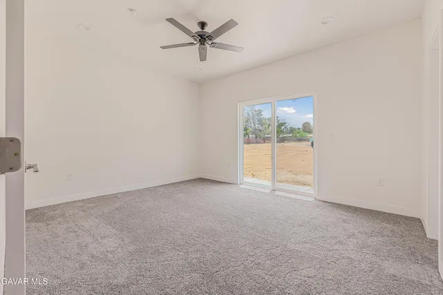 an empty room with closet and a ceiling fan