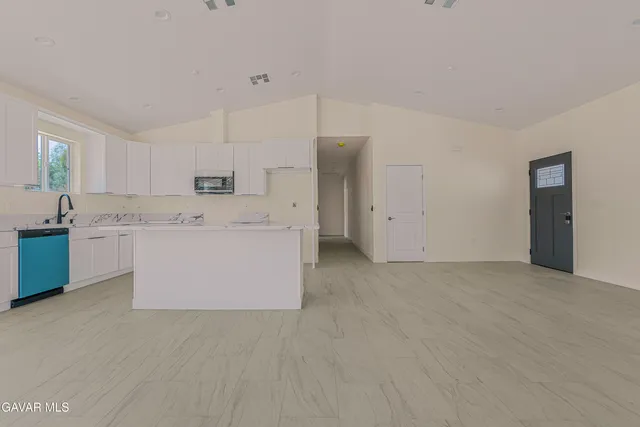 a view of kitchen with stainless steel appliances cabinets and a refrigerator