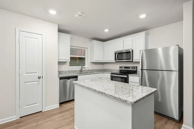 a kitchen with a refrigerator a microwave a sink and a stove top oven