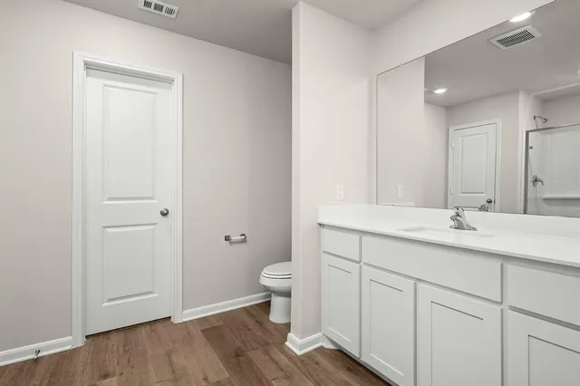 a bathroom with a granite countertop sink toilet and mirror
