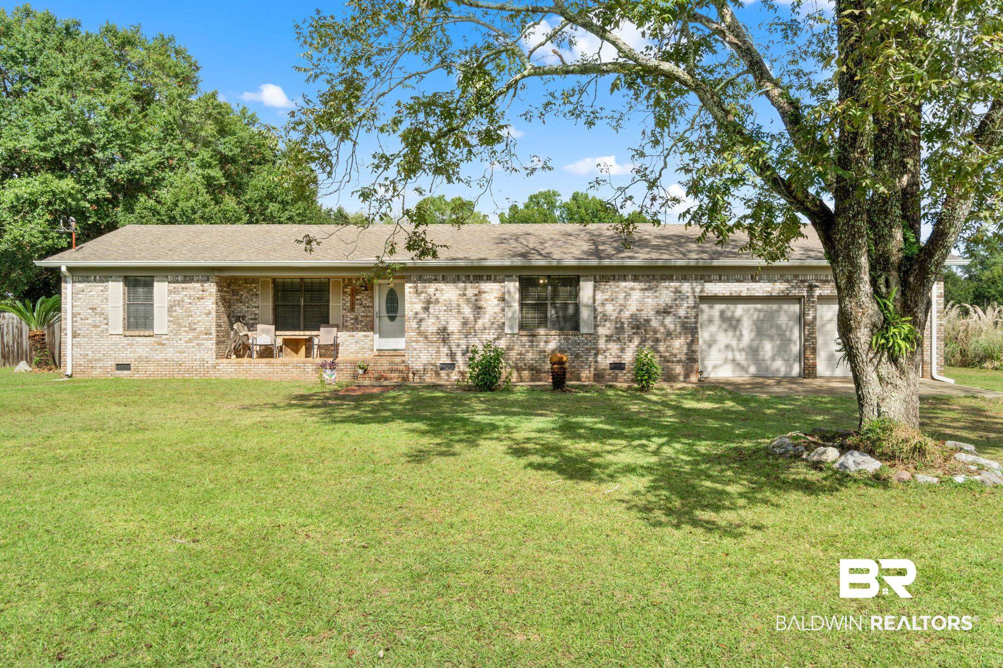 Rear view of property with crawl space, a lawn, and brick siding