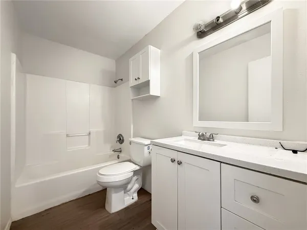 a bathroom with a granite countertop sink toilet a large mirror and shower