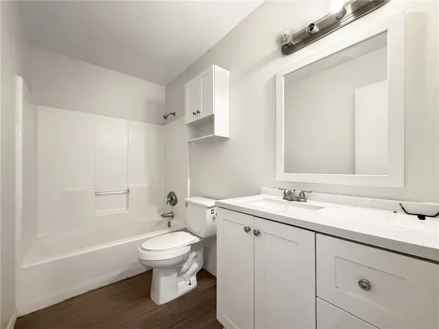 a bathroom with a granite countertop sink toilet a large mirror and shower
