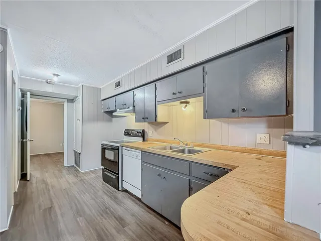 a kitchen with stainless steel appliances a stove a sink and a refrigerator