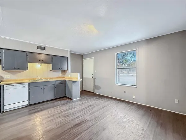 a large kitchen with a wooden floor and stainless steel appliances