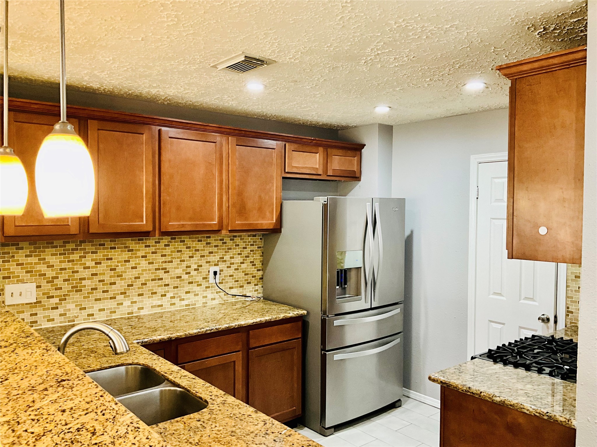 11827 Moss Branch Road Houston, TX 77043 - Photo 11 of 41 a kitchen with stainless steel appliances granite countertop a sink stove and refrigerator