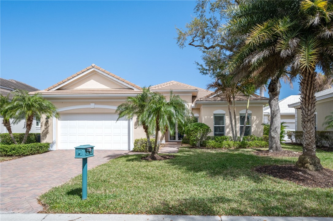 1101 River Wind Circle Vero Beach, FL 32967 - Photo 1 of 36 a front view of a house with a yard and palm trees