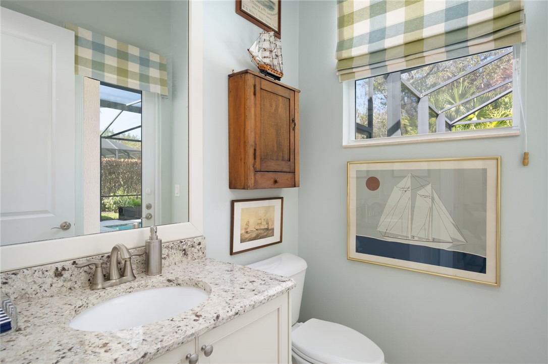 1101 River Wind Circle Vero Beach, FL 32967 - Photo 15 of 36 a bathroom with a granite countertop toilet a sink and mirror