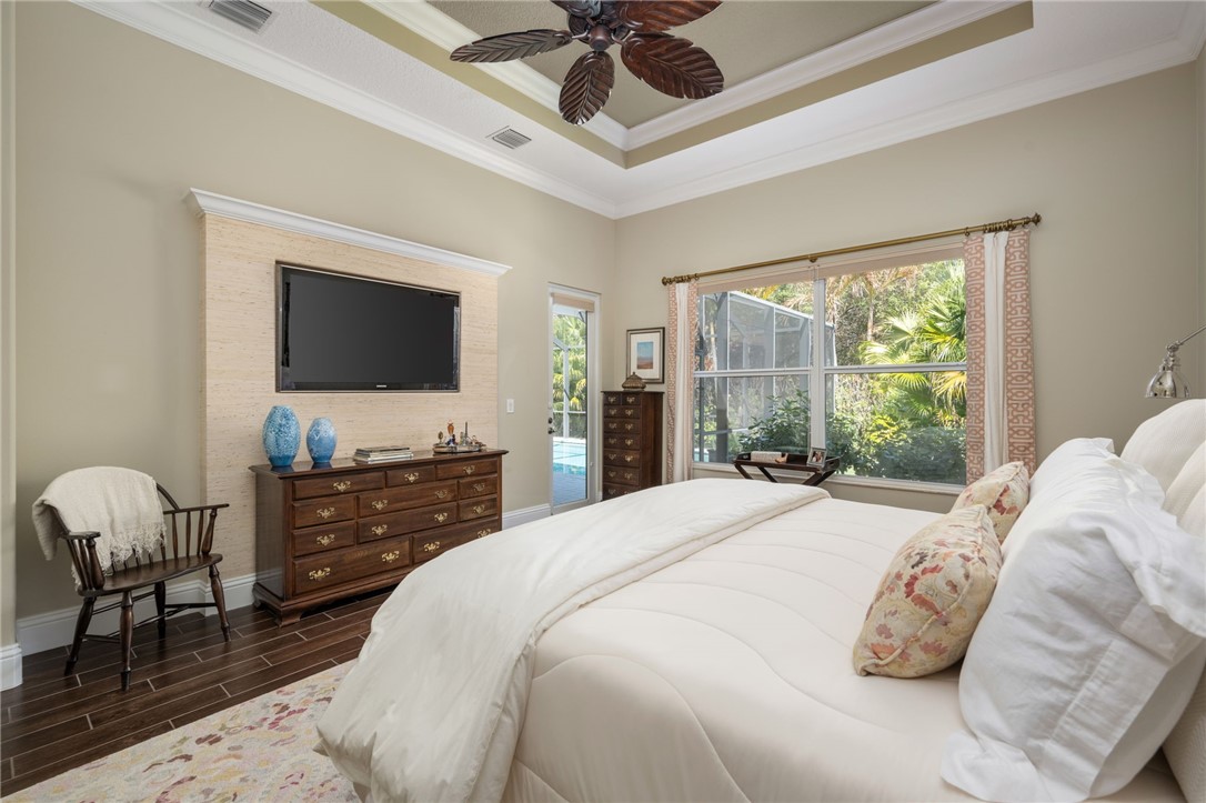 1101 River Wind Circle Vero Beach, FL 32967 - Photo 18 of 36 a bedroom with a bed and a flat screen tv