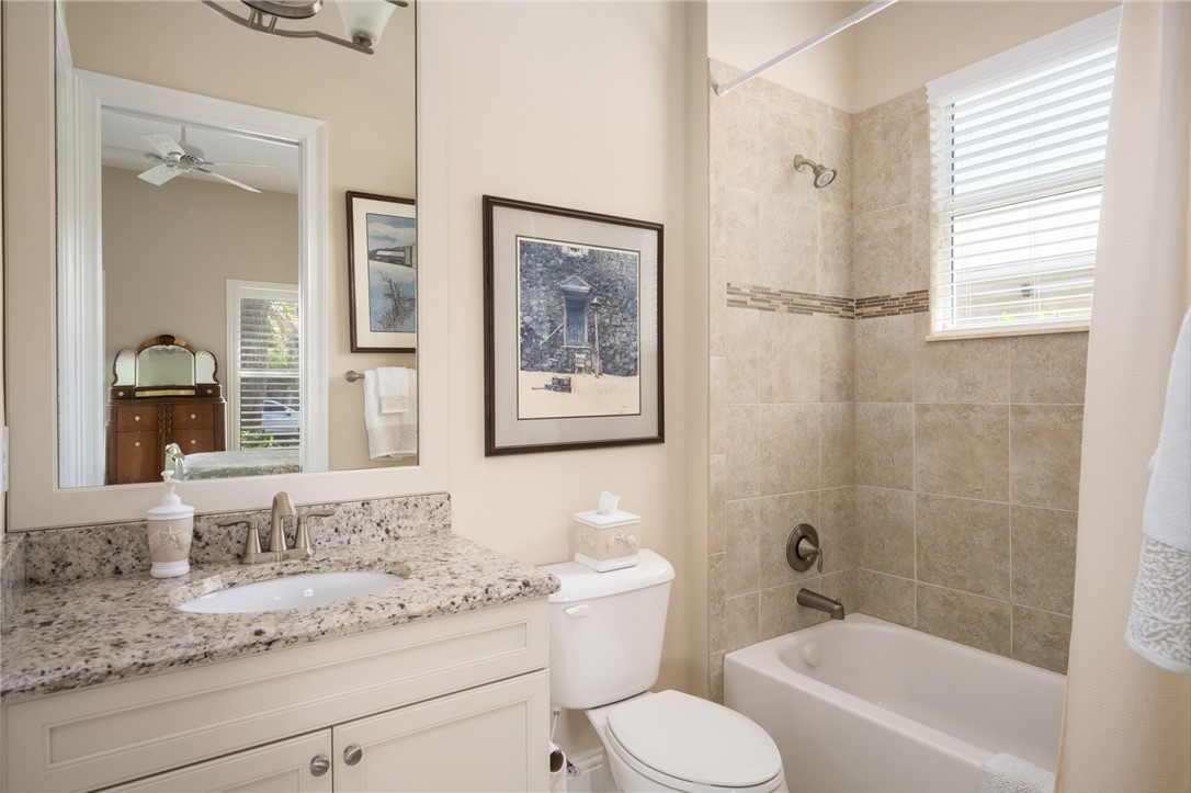 1101 River Wind Circle Vero Beach, FL 32967 - Photo 23 of 36 a bathroom with a granite countertop sink toilet and painting on the wall