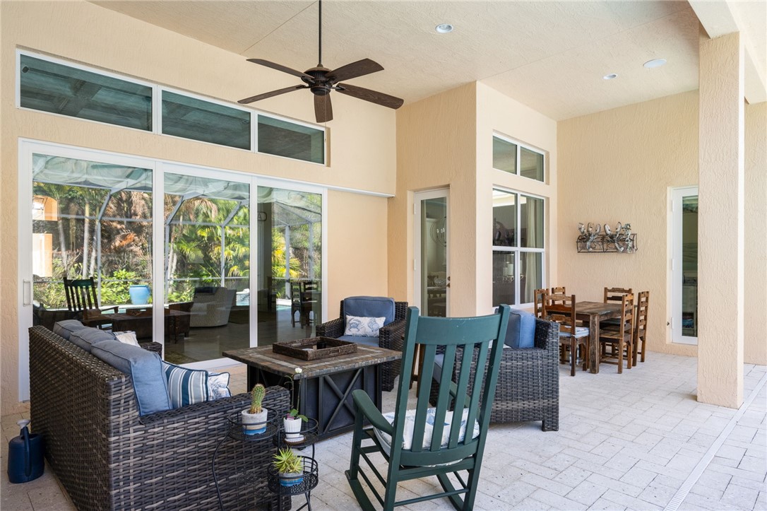 1101 River Wind Circle Vero Beach, FL 32967 - Photo 28 of 36 a dining room with furniture a floor to ceiling window and a table