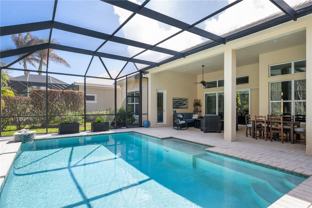 1101 River Wind Circle Vero Beach, FL 32967 - Photo 32 of 36 a view of a patio with a table and chairs under an umbrella